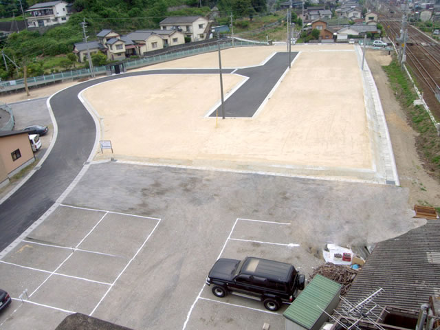 白い砂とアスファルトで綺麗に整備された駐車場
